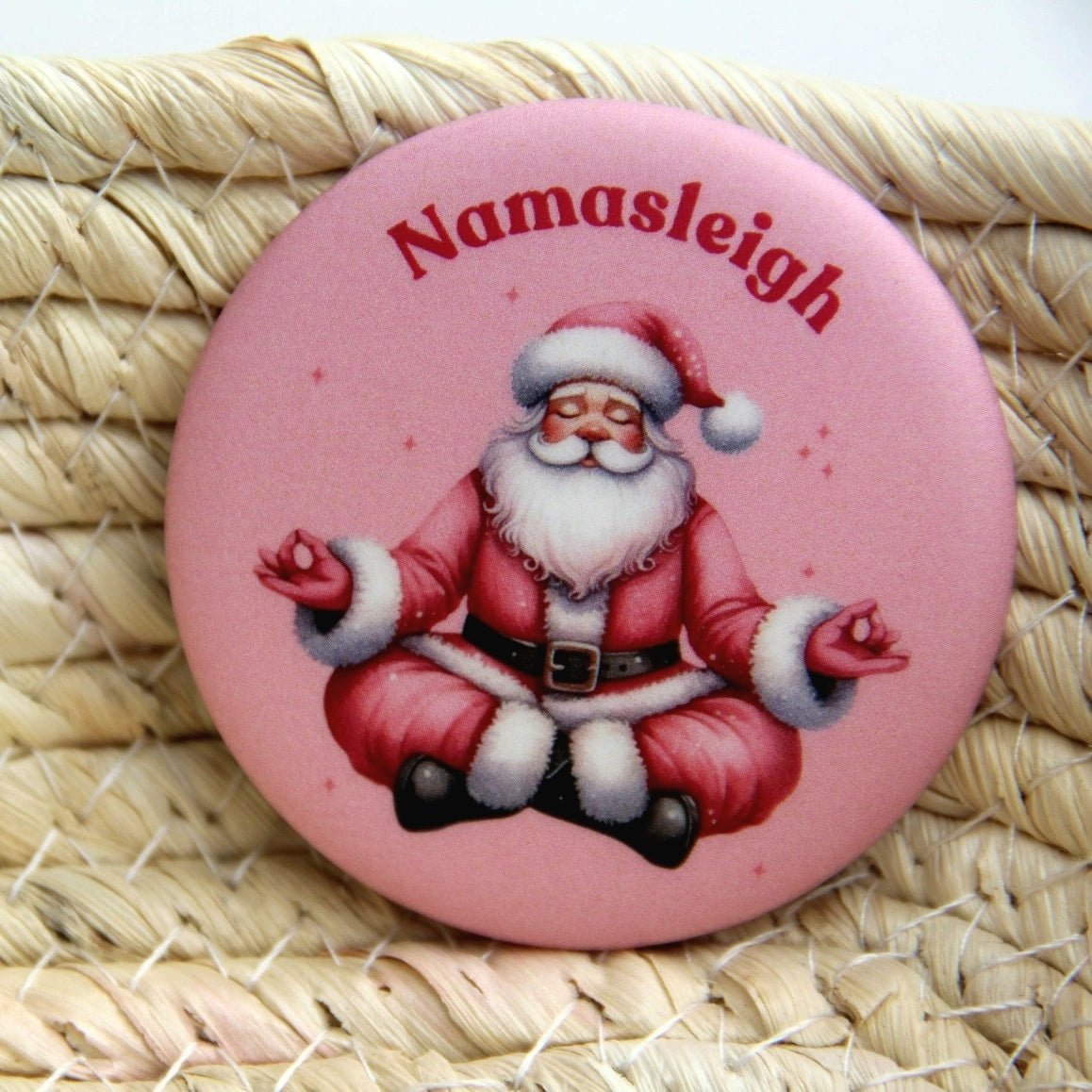 A Santa wearing a pink Santa suit doing a Yoga pose.